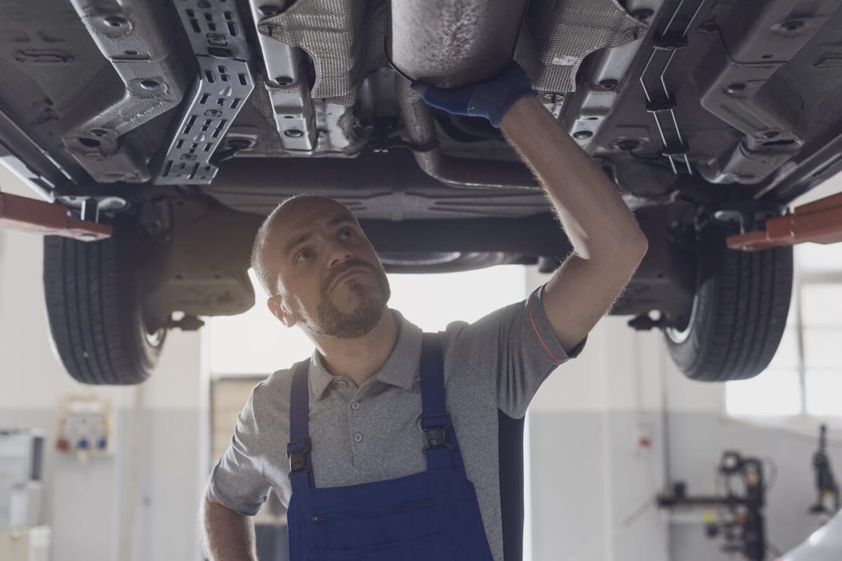 Mechanik sprawdza podwozie samochodu w celu czyszczenia filtra DPF.