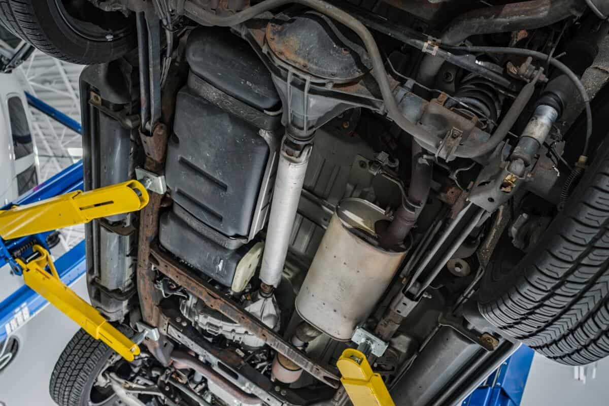 Podwozie samochodu na podnośniku w trakcie przeglądu i czyszczenia filtra DPF.