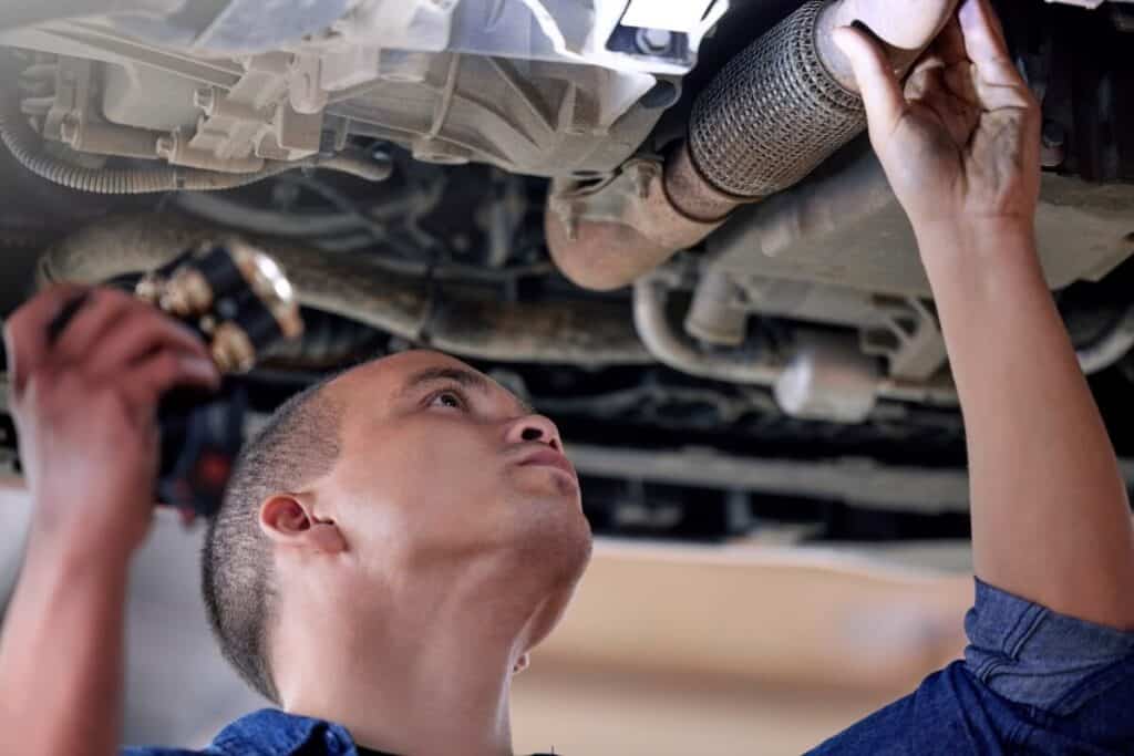 Mechanik pracuje pod samochodem podczas czyszczenia filtra DPF.
