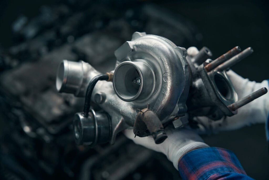 Mechanik przeprowadza regenerację turbosprężarki w warsztacie samochodowym.