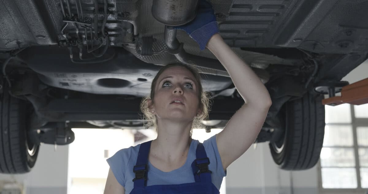 Mechanik kobieta wykonuje czyszczenie filtra DPF w warsztacie samochodowym.