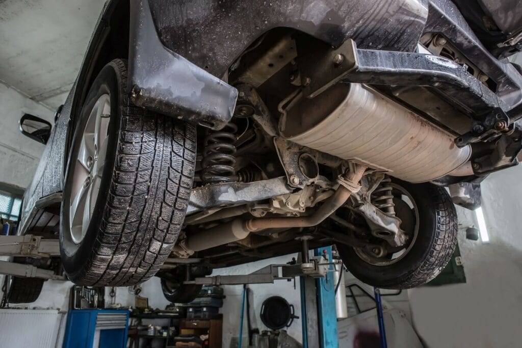 Samochód na podnośniku warsztatowym przechodzi regenerację katalizatora SCR.