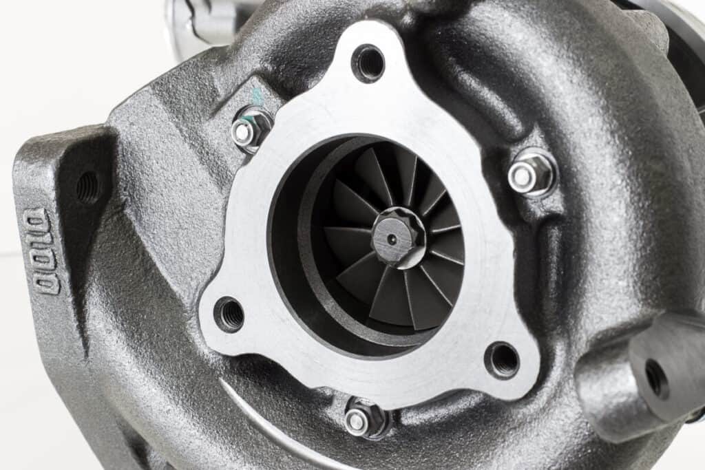 Obraz przedstawia zbliżenie turbosprężarki, co sugeruje potrzebę jej regeneracji turbosprężarki.