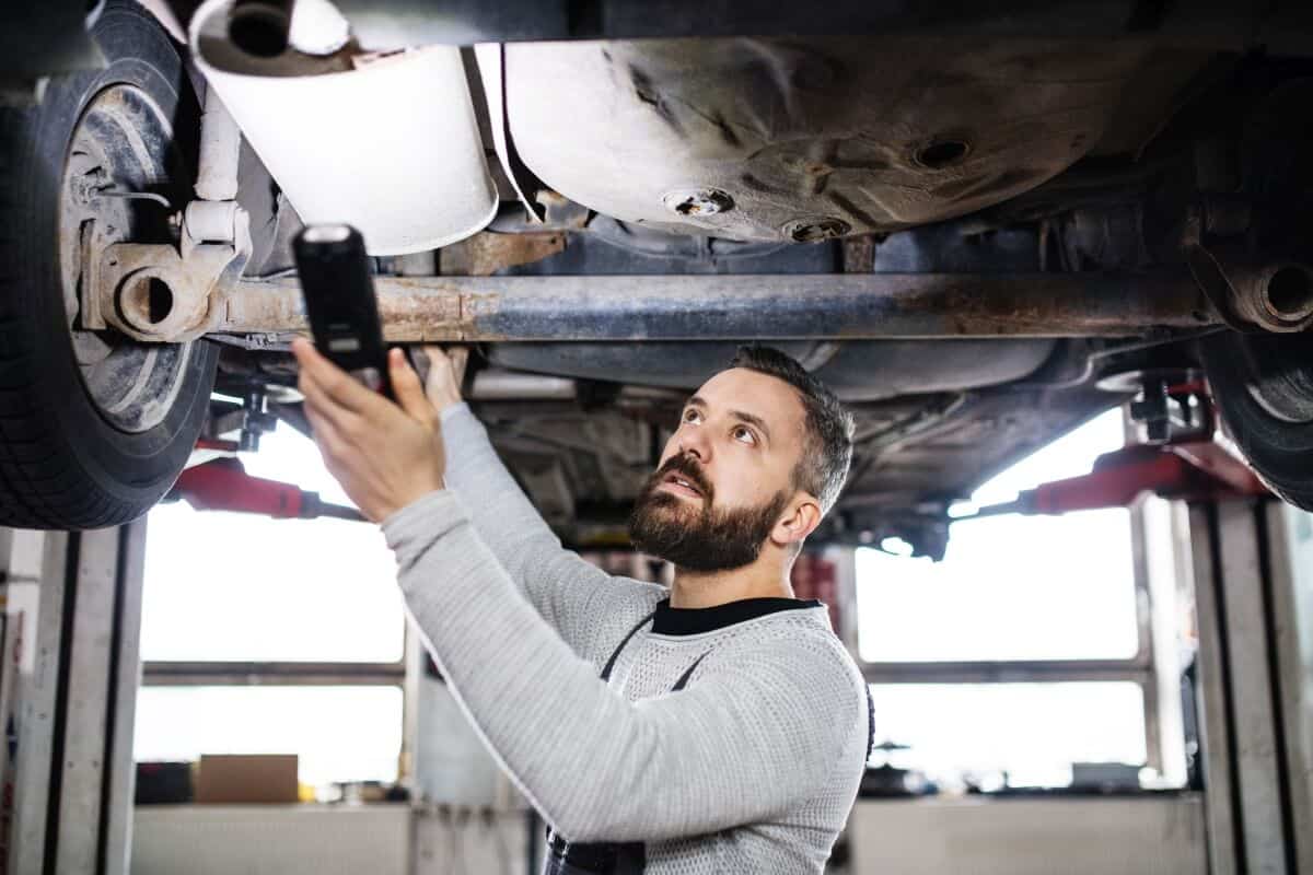 Mechanik ogląda podwozie auta na podnośniku w sprawie czyszczenia filtra DPF